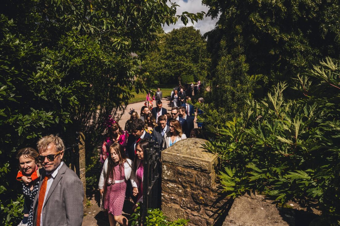 documentary wedding photography; dewsall court guests on their way to the main house