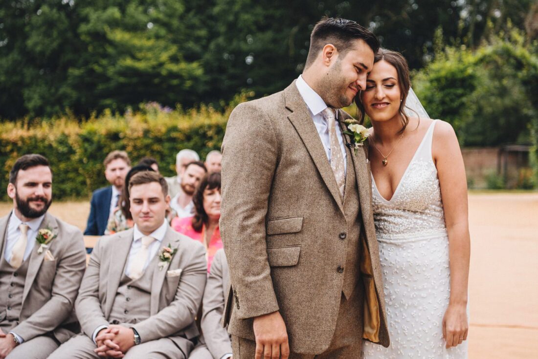 a bride and groom standing together during their wedding ceremony in a garden at Homme House