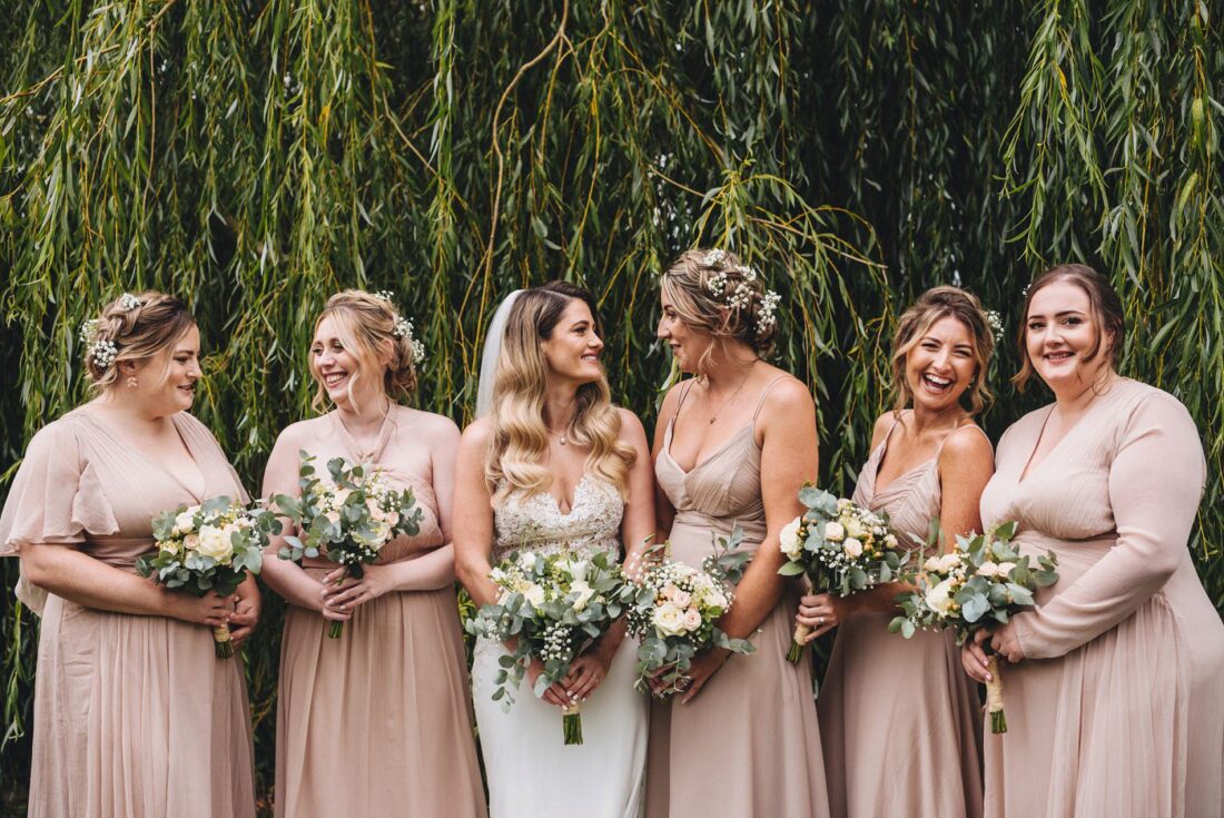 bride and bridesmaids standing in front of a willow tree at Deer Park