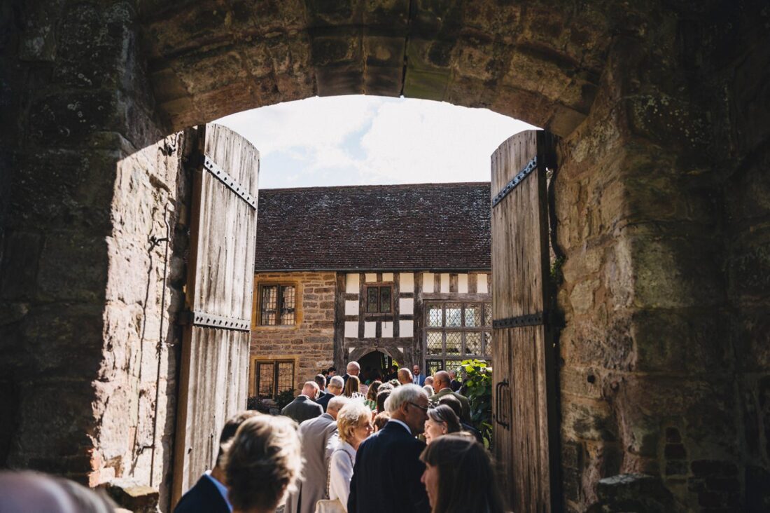 the main entrance to the moat house at birtsmorton court and guests entering the courtyard and enjoying the drinks