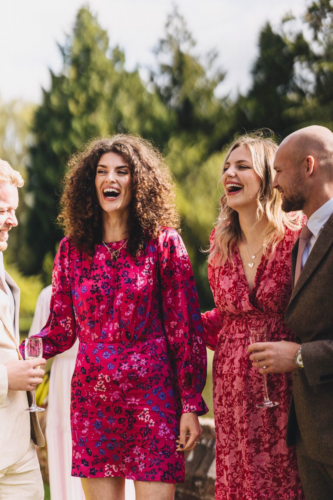 wedding guests laughing and enjoying reception drinks on the terrace at Birtsmorton Court