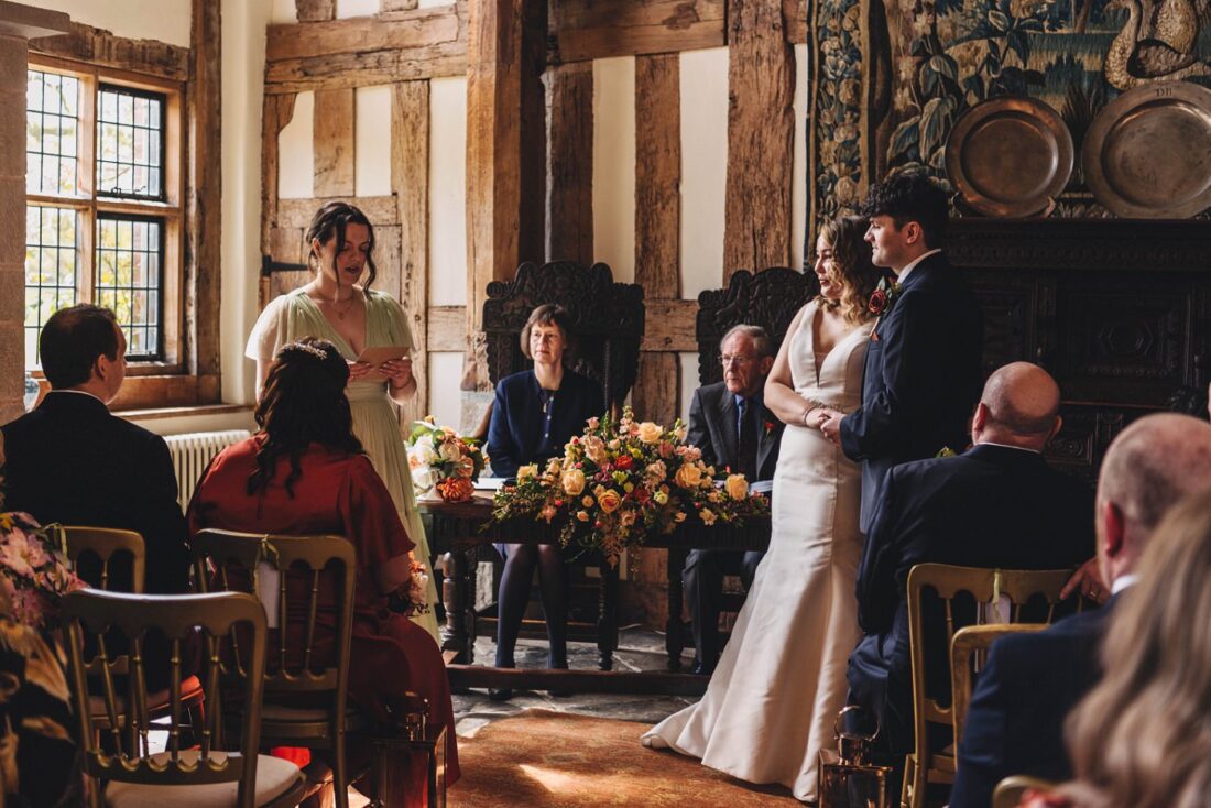 maid of honour reading the poem during the civil ceremony at Birtsmorton Court, couple standing next to her and holding hands