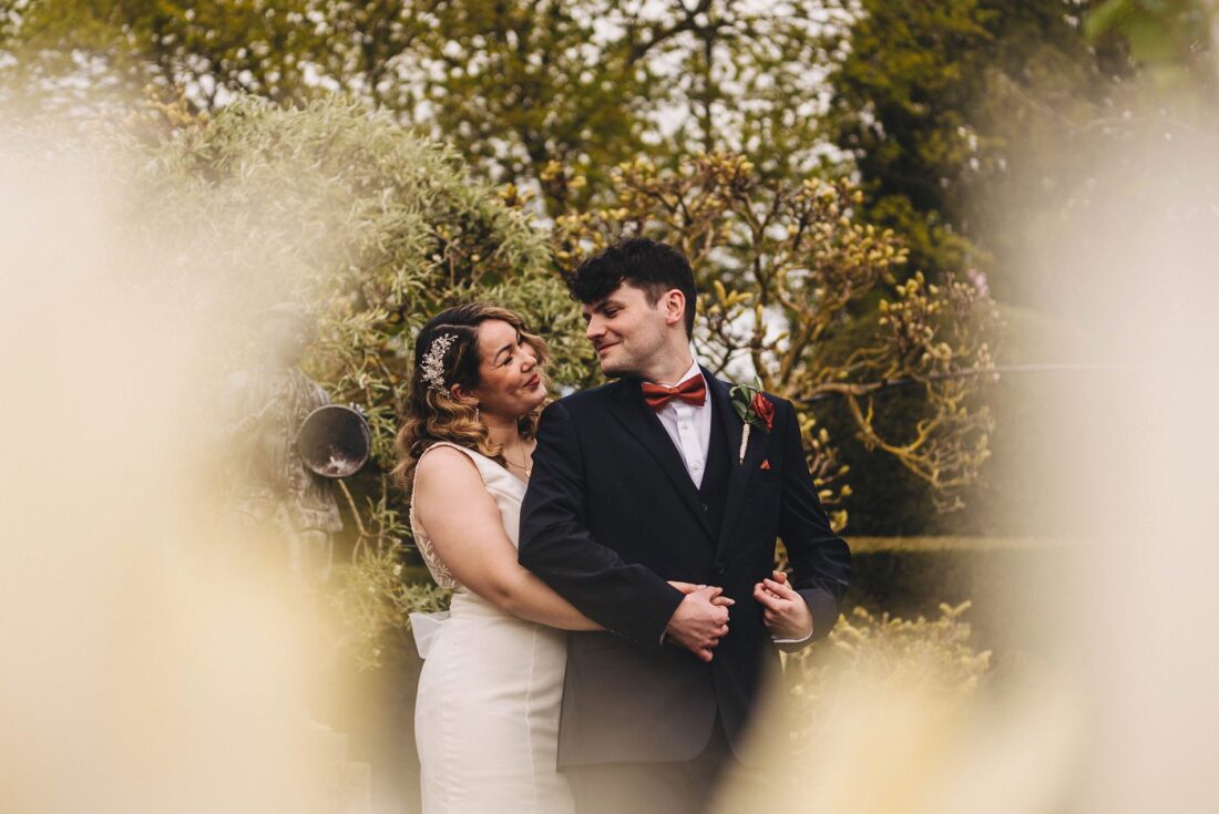 bride and groom standing and looking at each other in the white garden at Birtsmorton Court