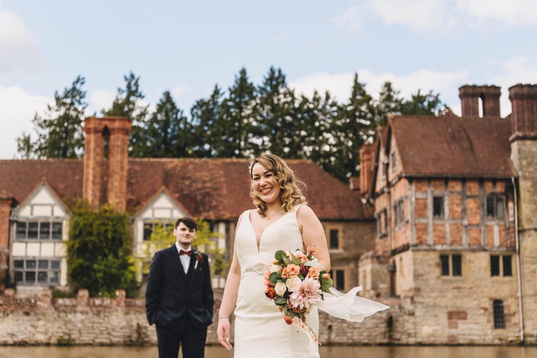 bride and groom posing on a nice day in front of Birtsmorton Court