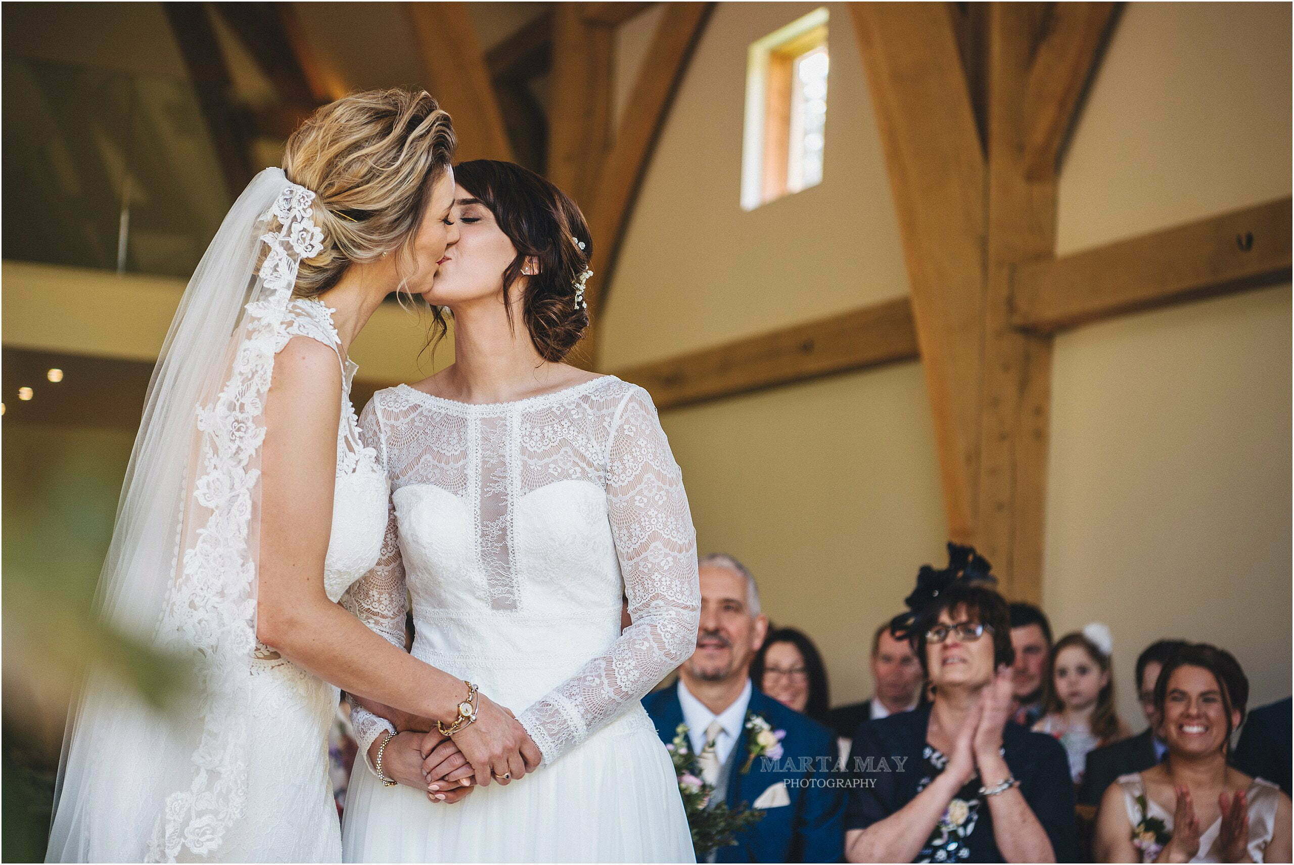 two brides just married and kissing at the mill barns wedding venue