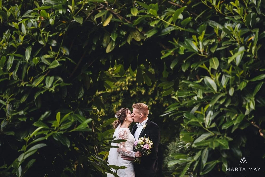 Homme House weddings Just married bride and groom kissing in the gardens