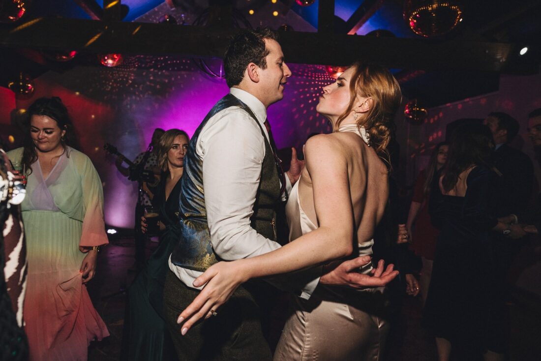 bride and groom dancing the night away at Dewsall Court surrounded by guests dancing and having fun