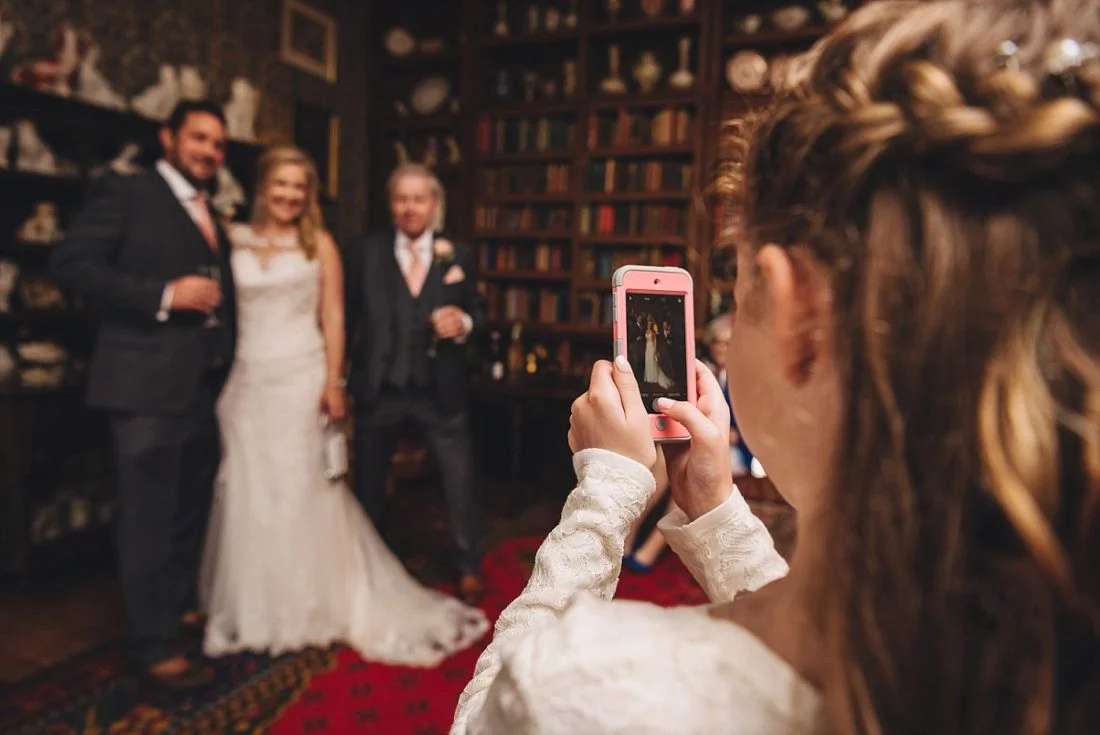 bride and groom posing for the picture in the library at Homme House