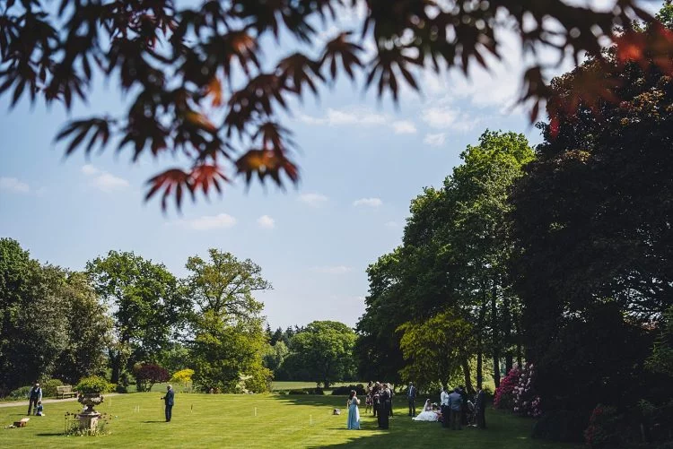 wedding guests enjoying the sun on the front lawn at Homme House