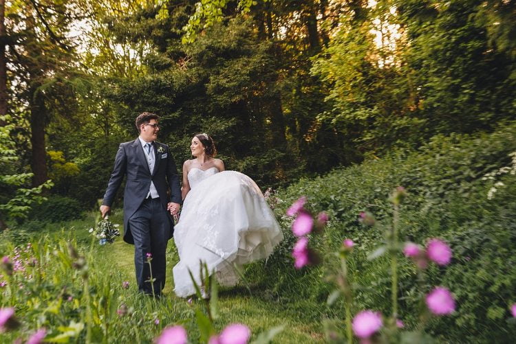 bride and groom walking through the woodland area at Homme House