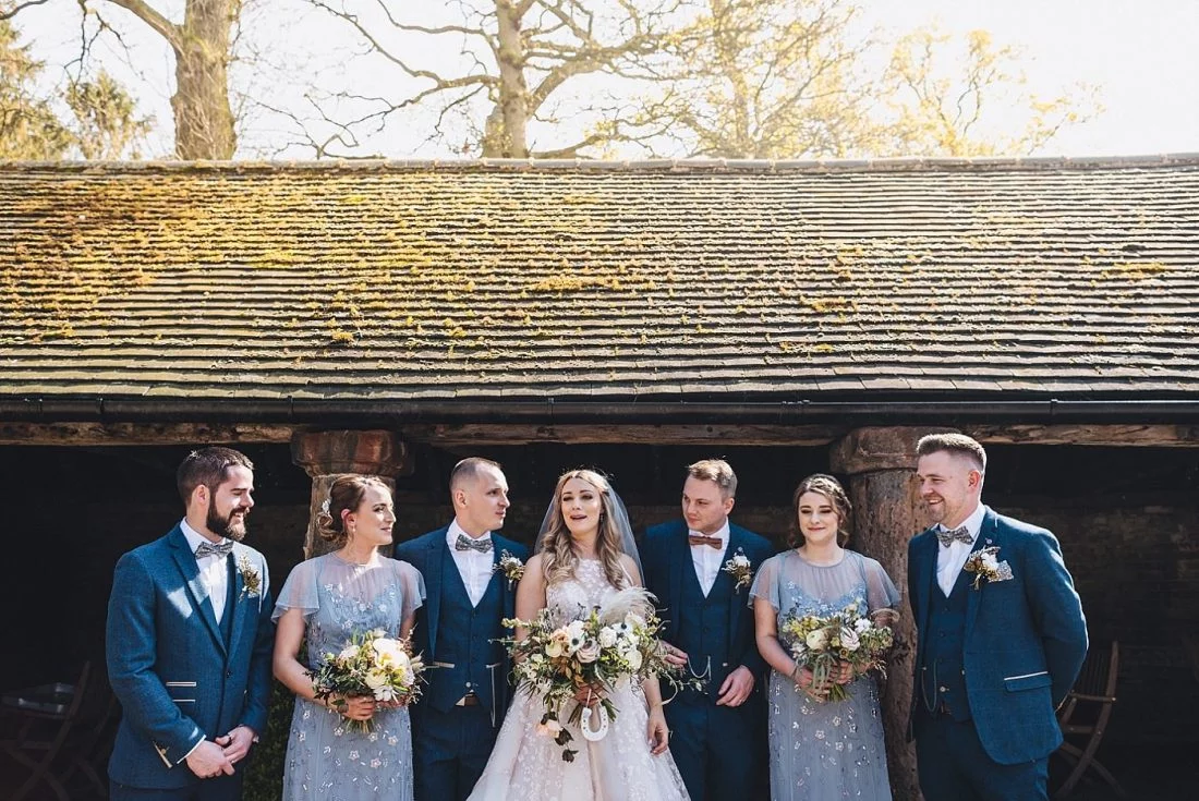 bride, groom, bridesmaids and groomsmen posing for a group picture at Shustoke Barn