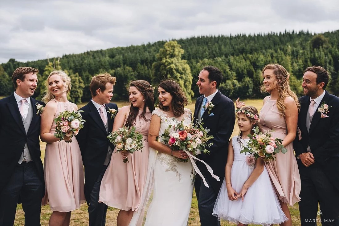 bride and groom posing for the group picture and laughing at Walcot Hall