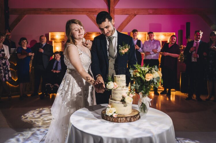 bride and groom cutting wedding cake at redhouse barn