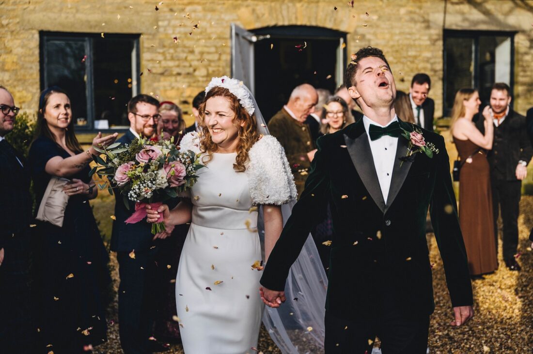 bride and groom having a confetti moment surrounded by their wedding guests