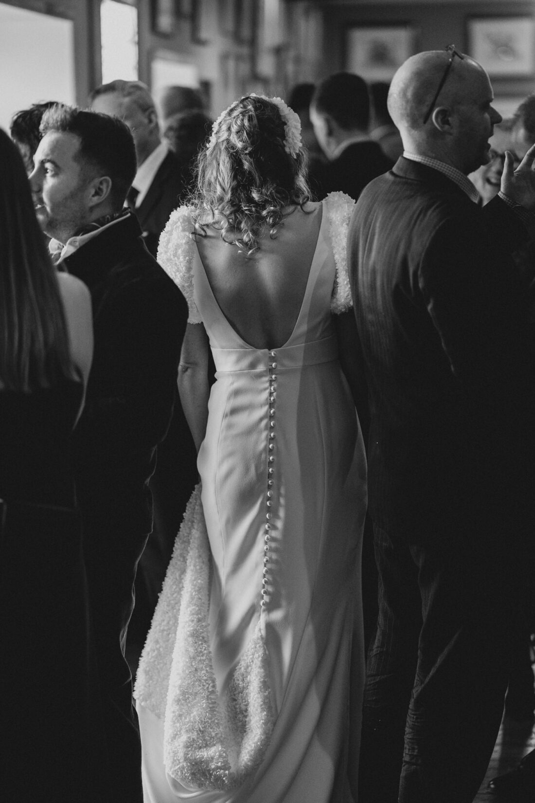 bride walking through the crowd during the reception drinks at Merriscourt