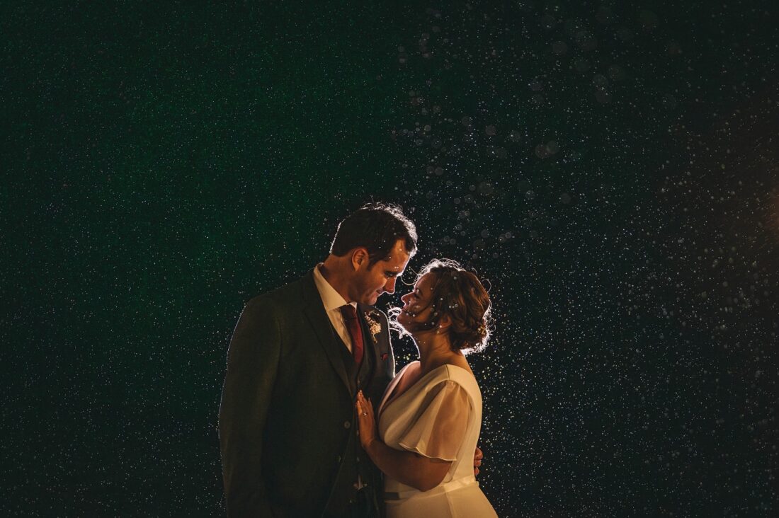 backlit picture of the couple standing in the rain at night at Bredenbury Court