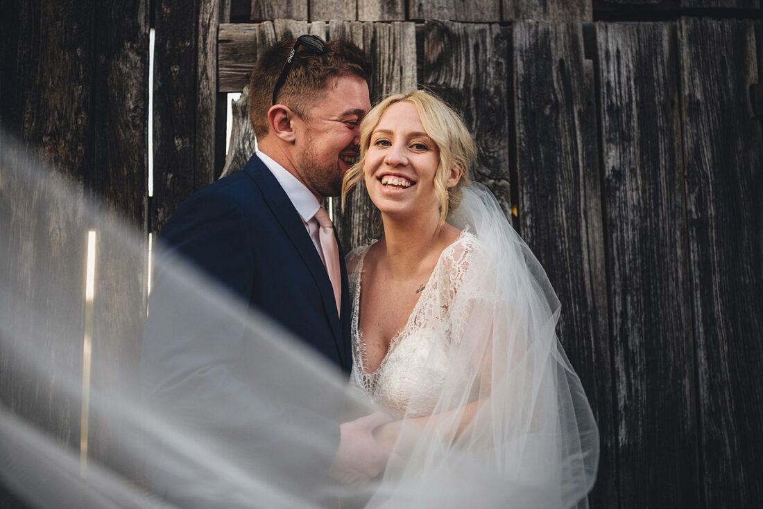 broadfield court wedding photography bride and groom laughing together long veil