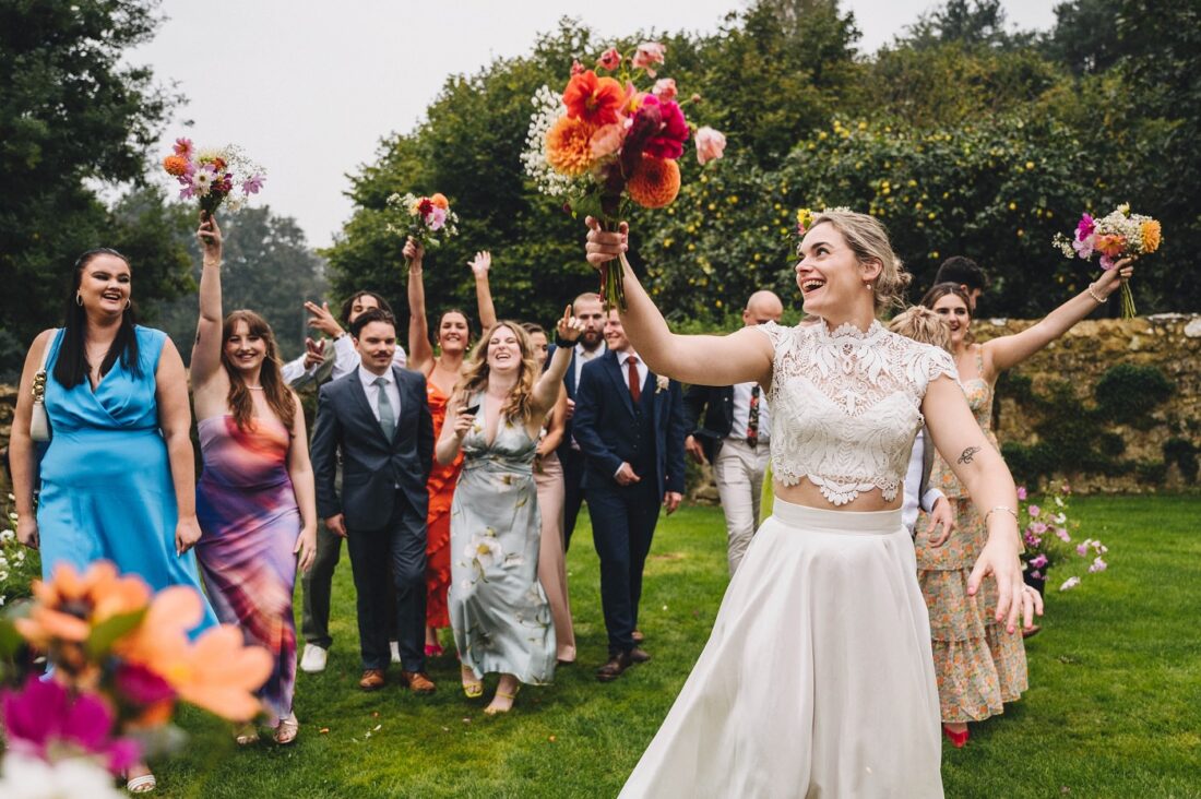 bride throwing her bouquet during a wedding at Dillington Estate, Somerset wedding venues