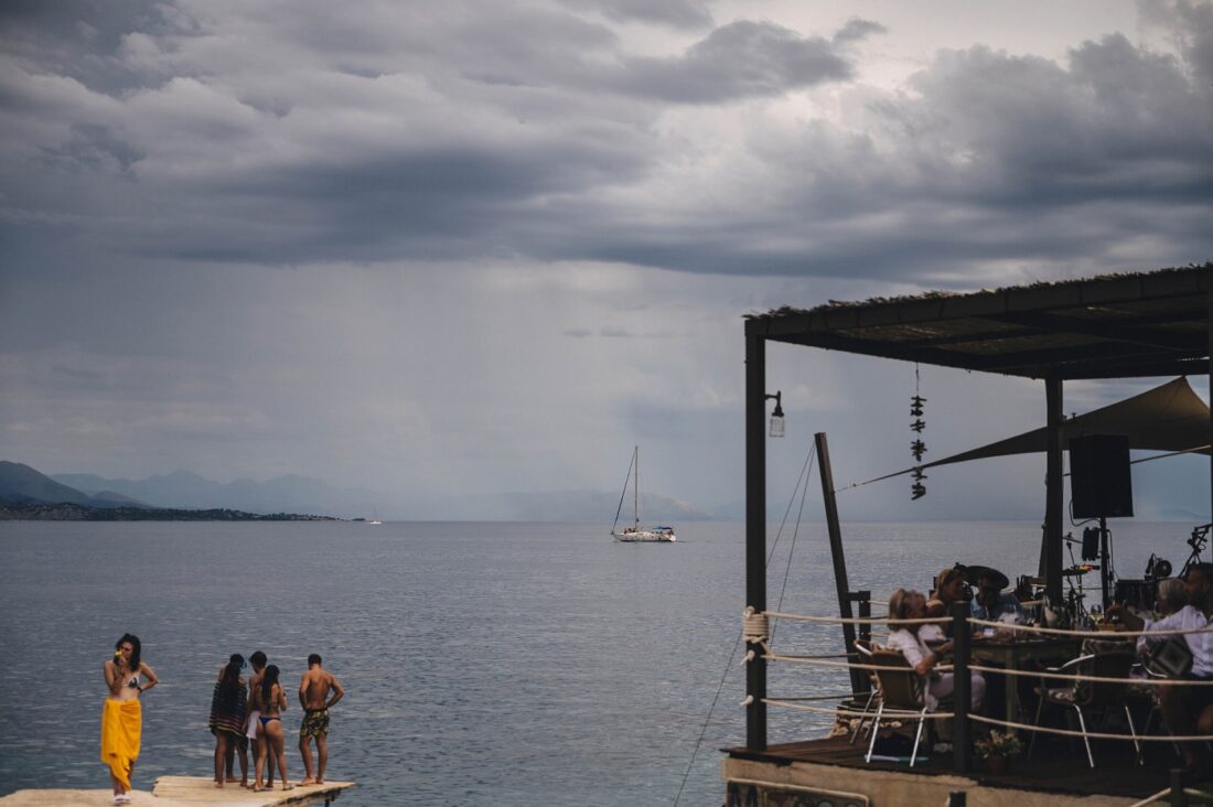 moments before the rain, boat on the sea, tourists to the left and wedding guests enjoying their meal to the right