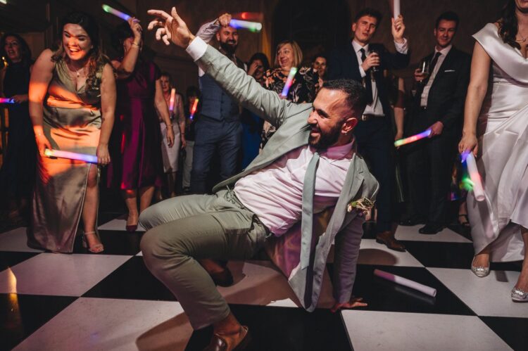a bridesman doing the dance off on a dance floor at Stanbrook Abbey