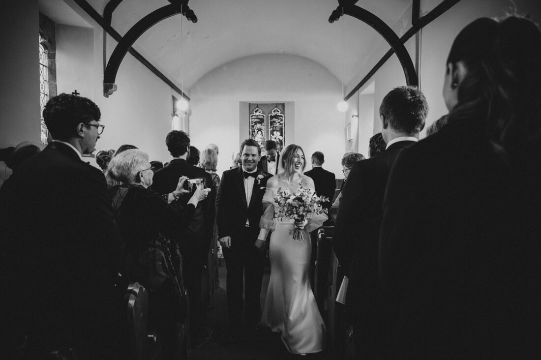 just married couple leaving the church at Dewsall Court