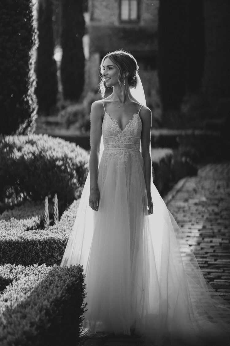 bride standing in the gloriuos afternoon light in the courtyard at Old Downton Lodge