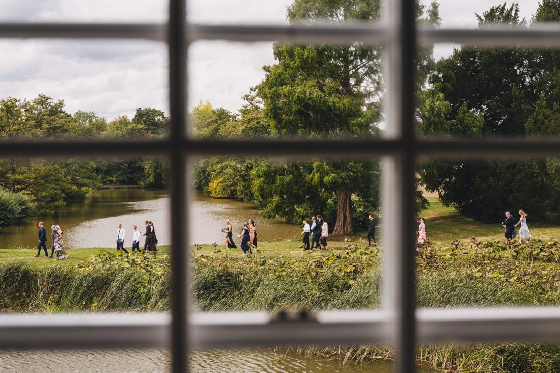 wedding guests on the way to the ceremony by the moat