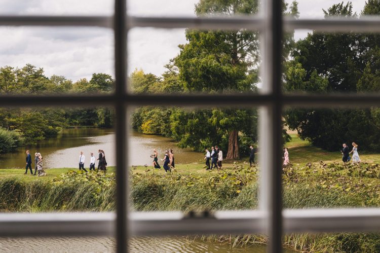 wedding guests on the way to the ceremony by the moat
