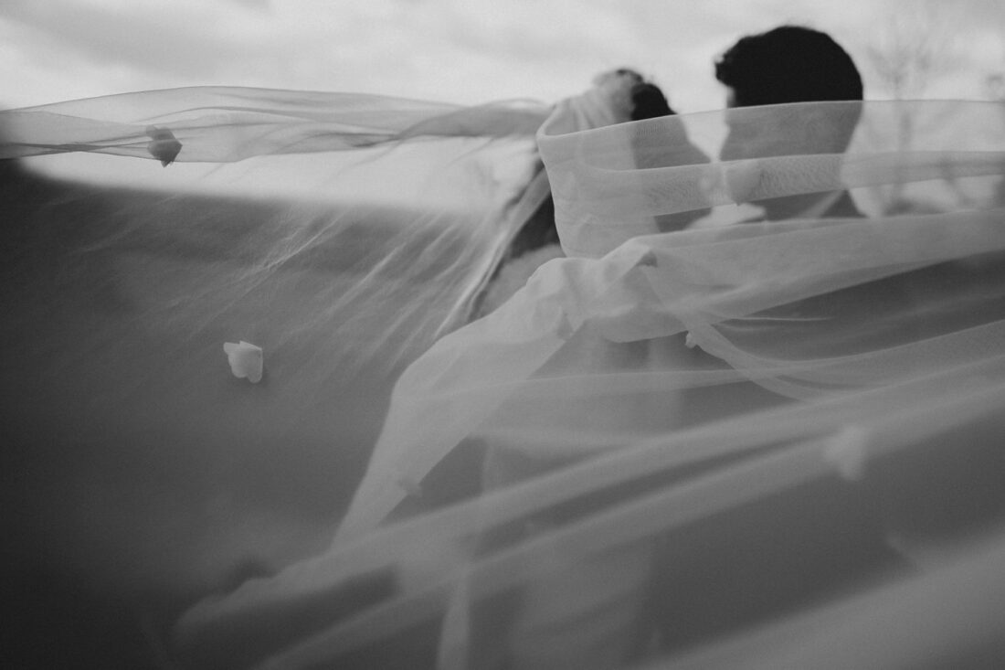 bride and groom hugging under the veil at Merriscourt