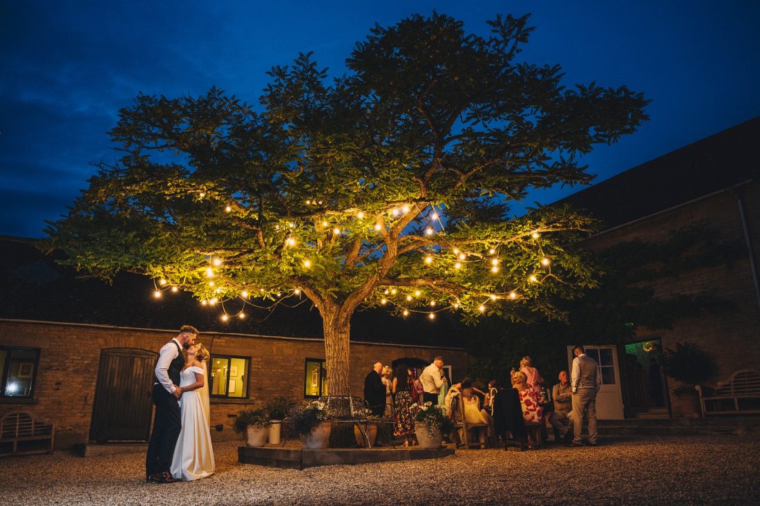 the courtyard at merrisocurt at night with fairy lights and sparklers, blue hour wedding photography