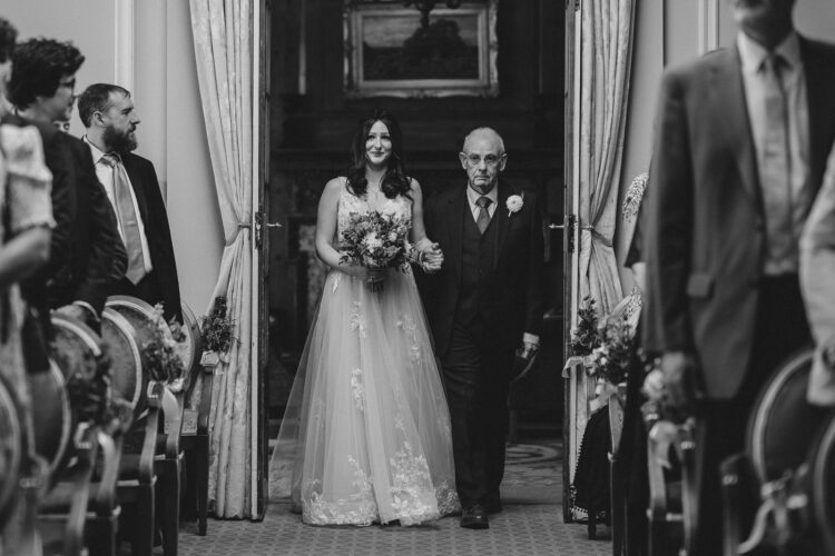 bride entering the ceremony room with her dad