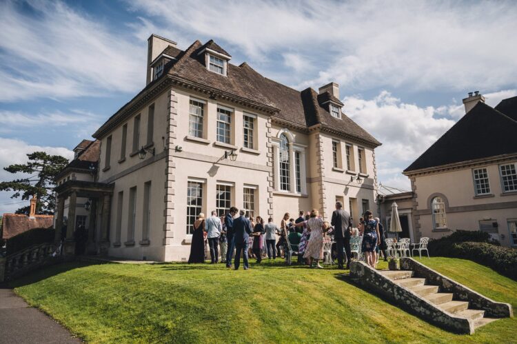 wedding guests mingling during reception drinks at Brockencote Hall