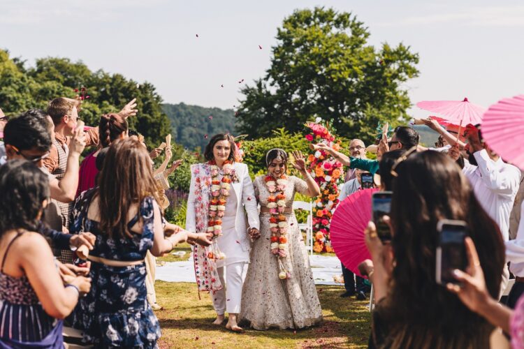 LGBTQ wedding photographer confetti moment after outdoor hindu wedding ceremony at How Caple Court