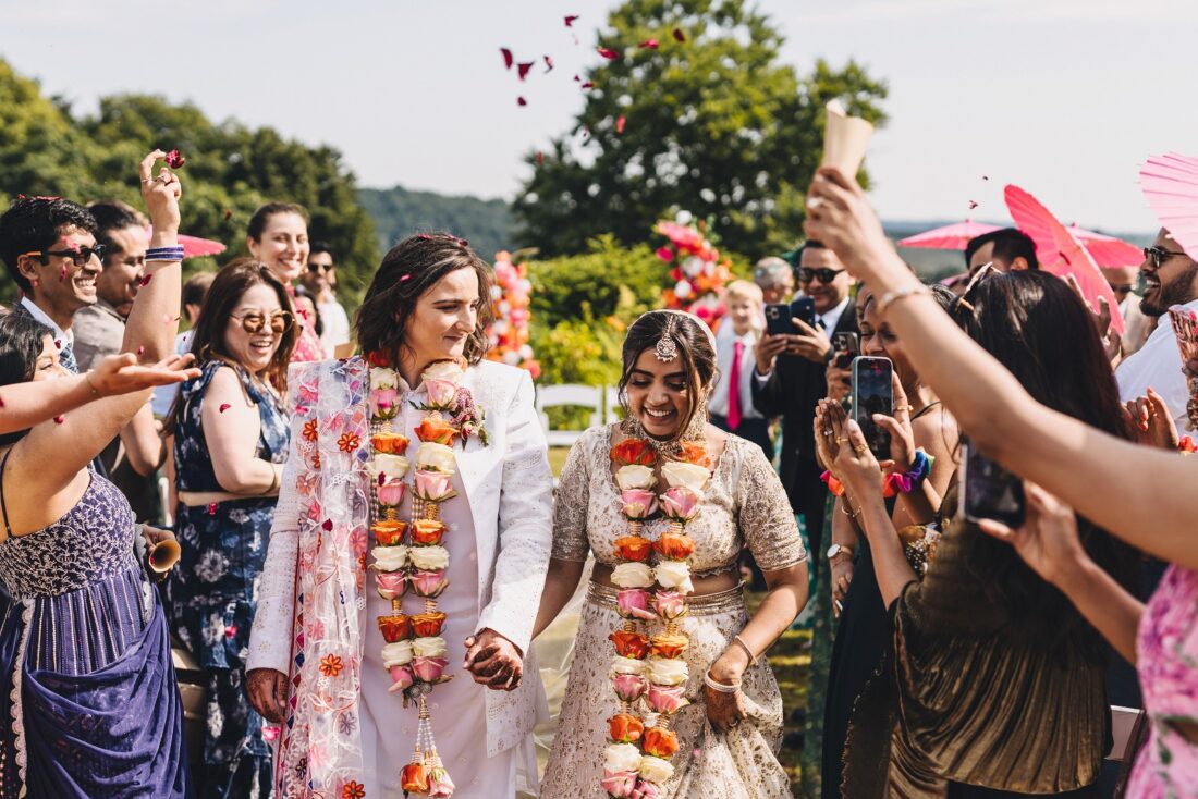 LGBTQ wedding photographer confetti moment after outdoor hindu wedding ceremony at How Caple Court