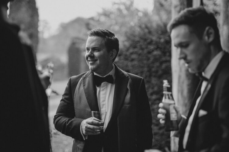 groom welcoming guests at Dewsall Court